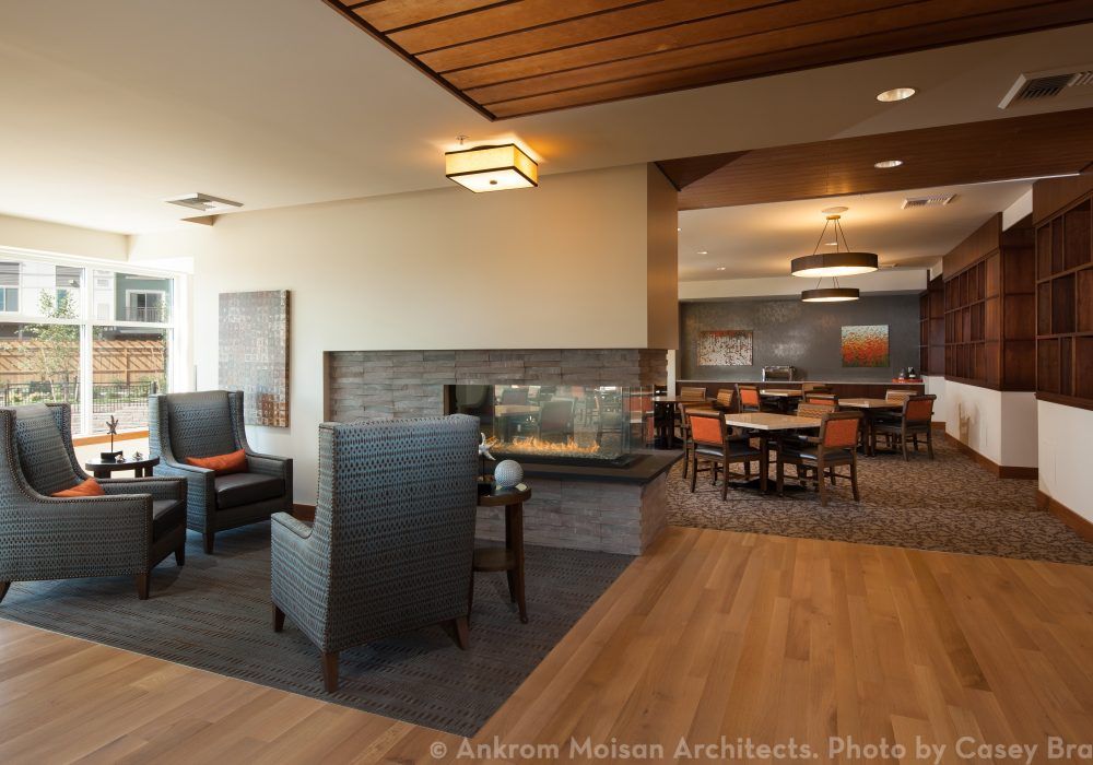 A modern lounge area featuring a central fireplace and stylish seating arrangements.