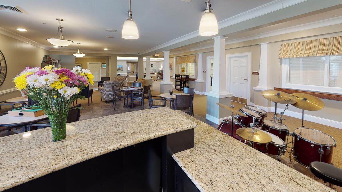 A modern open-plan living and dining area featuring a granite kitchen counter with pendant lighting.
