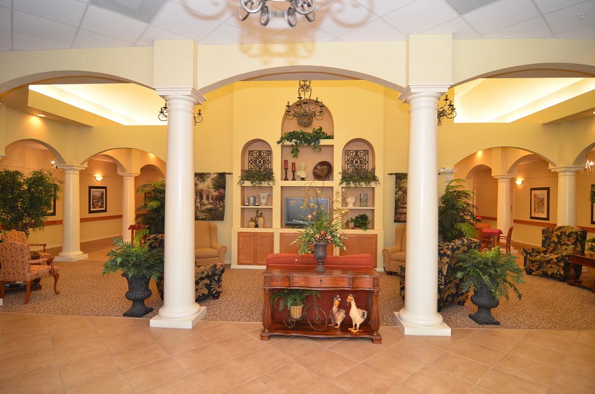 A cozy interior space featuring elegant columns, decorative plants, and a welcoming ambiance.