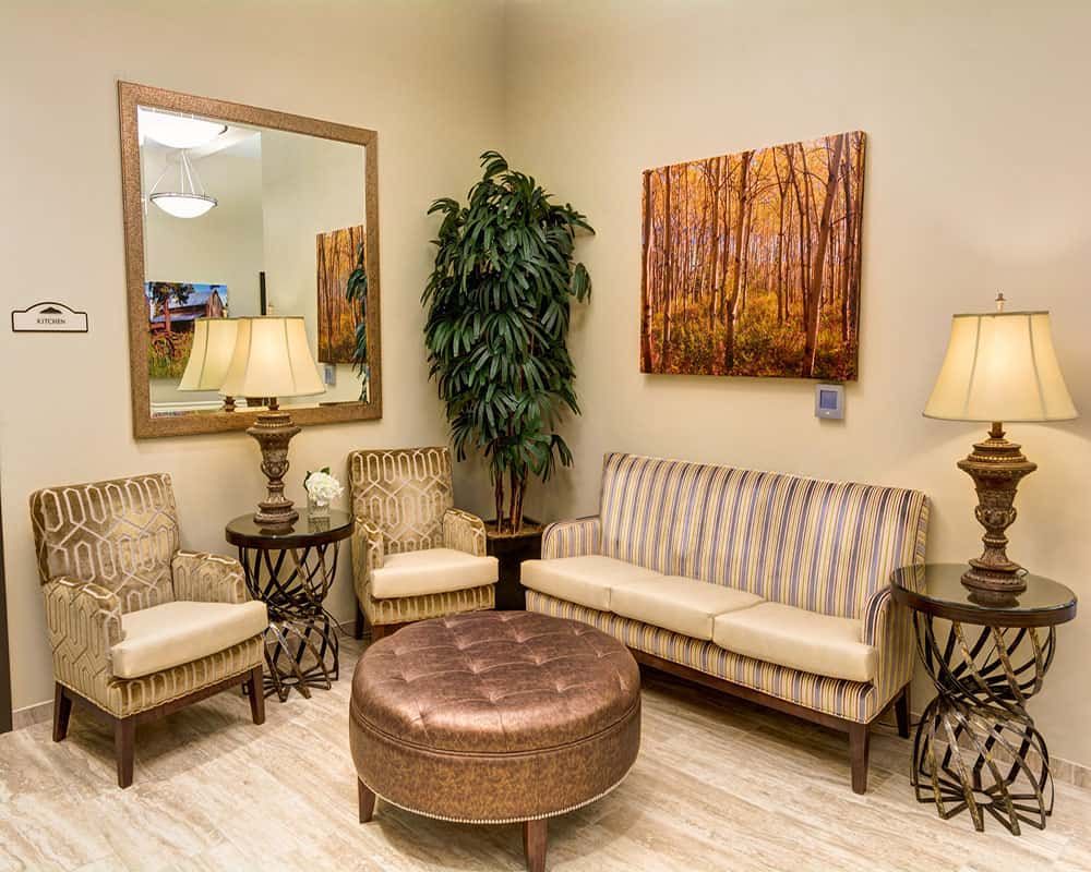 A cozy living room with comfortable seating, elegant lighting, and decorative art.