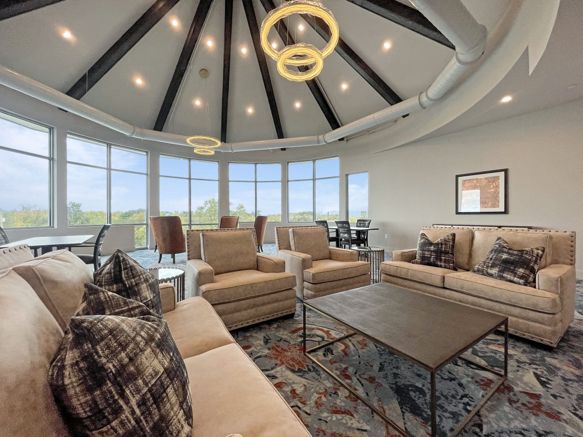 A modern living room with large windows, comfortable seating, and stylish lighting fixtures.