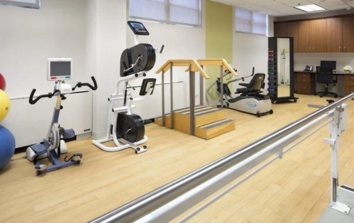 A rehabilitation gym with various exercise equipment for physical therapy.