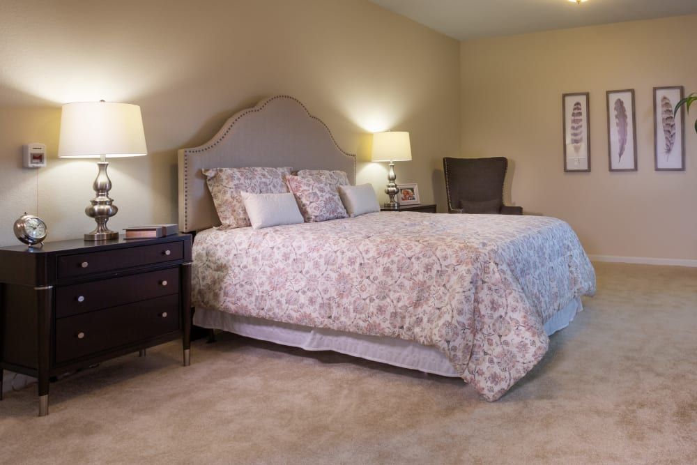 A cozy bedroom with a neatly made bed and elegant decor.