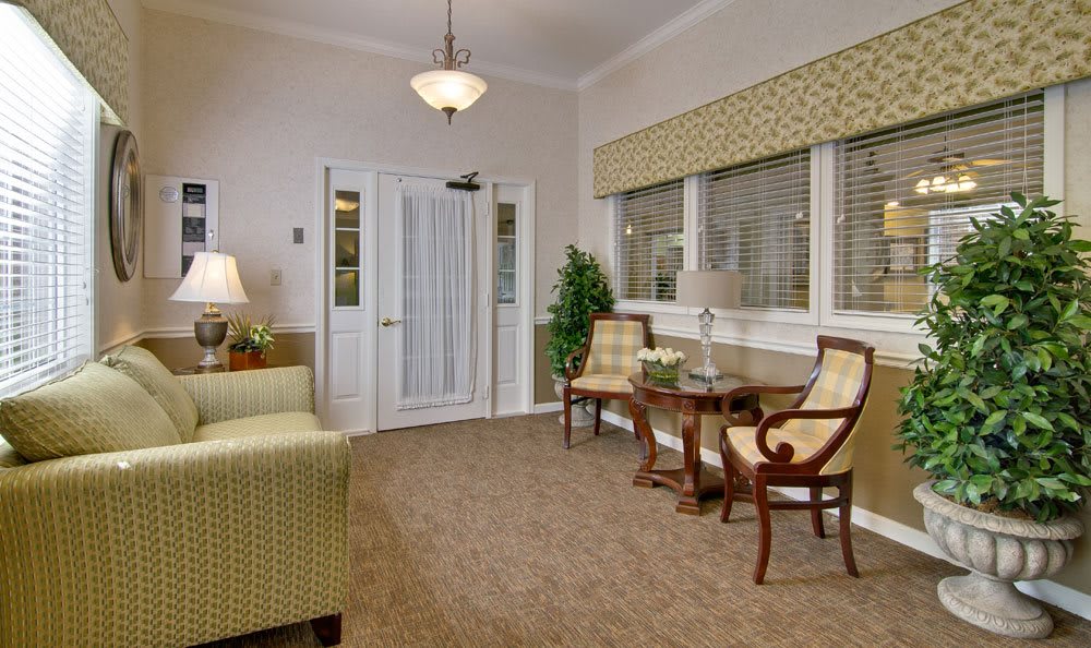 A cozy living room featuring elegant chairs, a small table, and soft lighting.