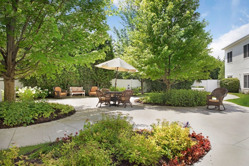 A serene garden patio with comfortable seating and lush greenery.