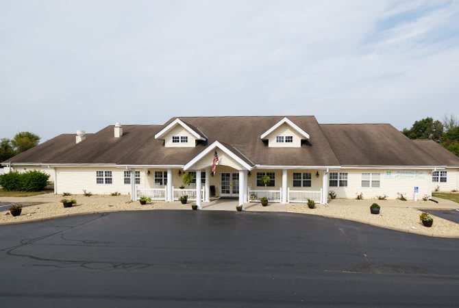 A suburban residential building with a large porch and gabled roof.