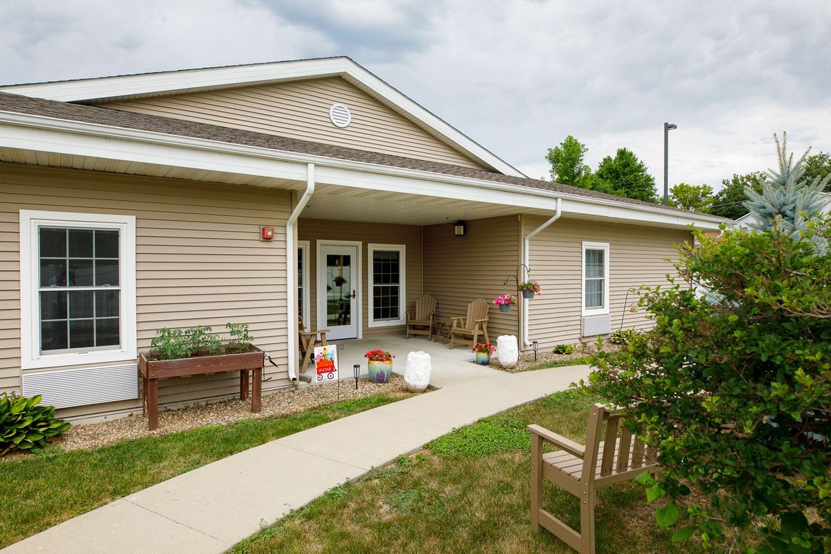 A small house with a porch and garden path leading to the entrance.