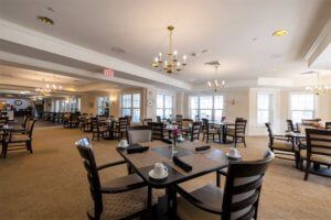 A spacious dining room with elegant lighting and neatly arranged tables.