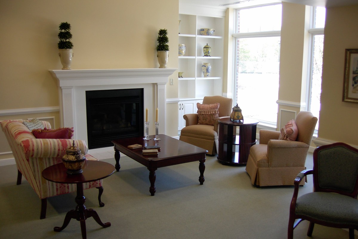 A cozy living room featuring a fireplace, armchairs, and a coffee table.