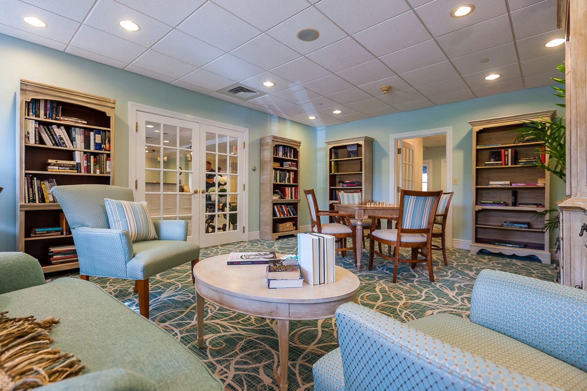 A cozy library reading area with comfortable seating and shelves full of books.