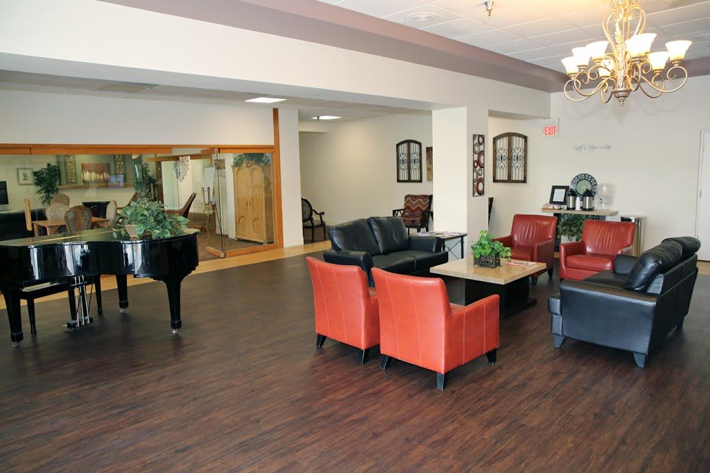 A cozy lounge area featuring comfortable seating, a piano, and stylish decor.