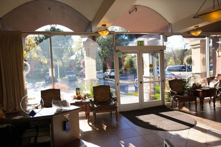 A sunlit waiting area with chairs and large windows.