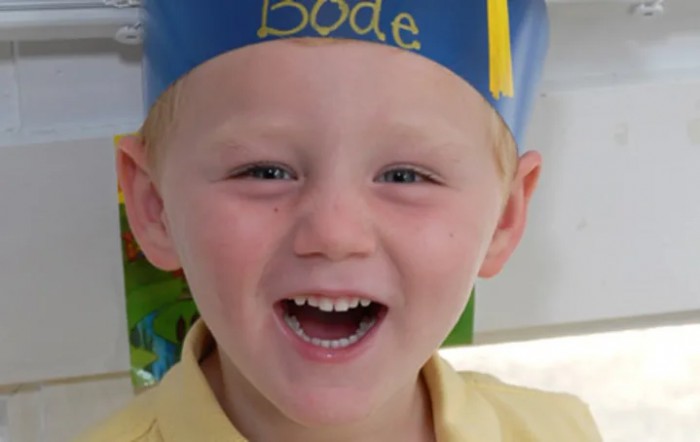 A smiling child wearing a party hat.