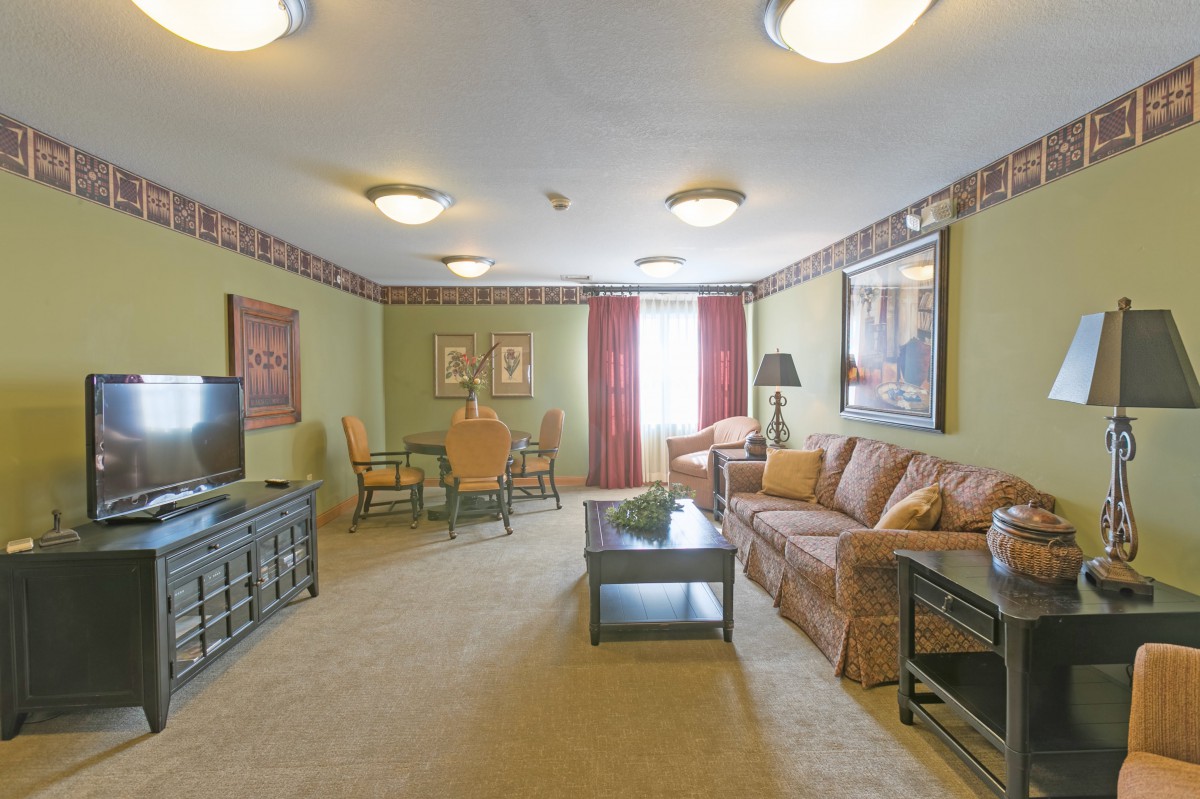 A well-furnished living room with a sofa, coffee table, and dining area.