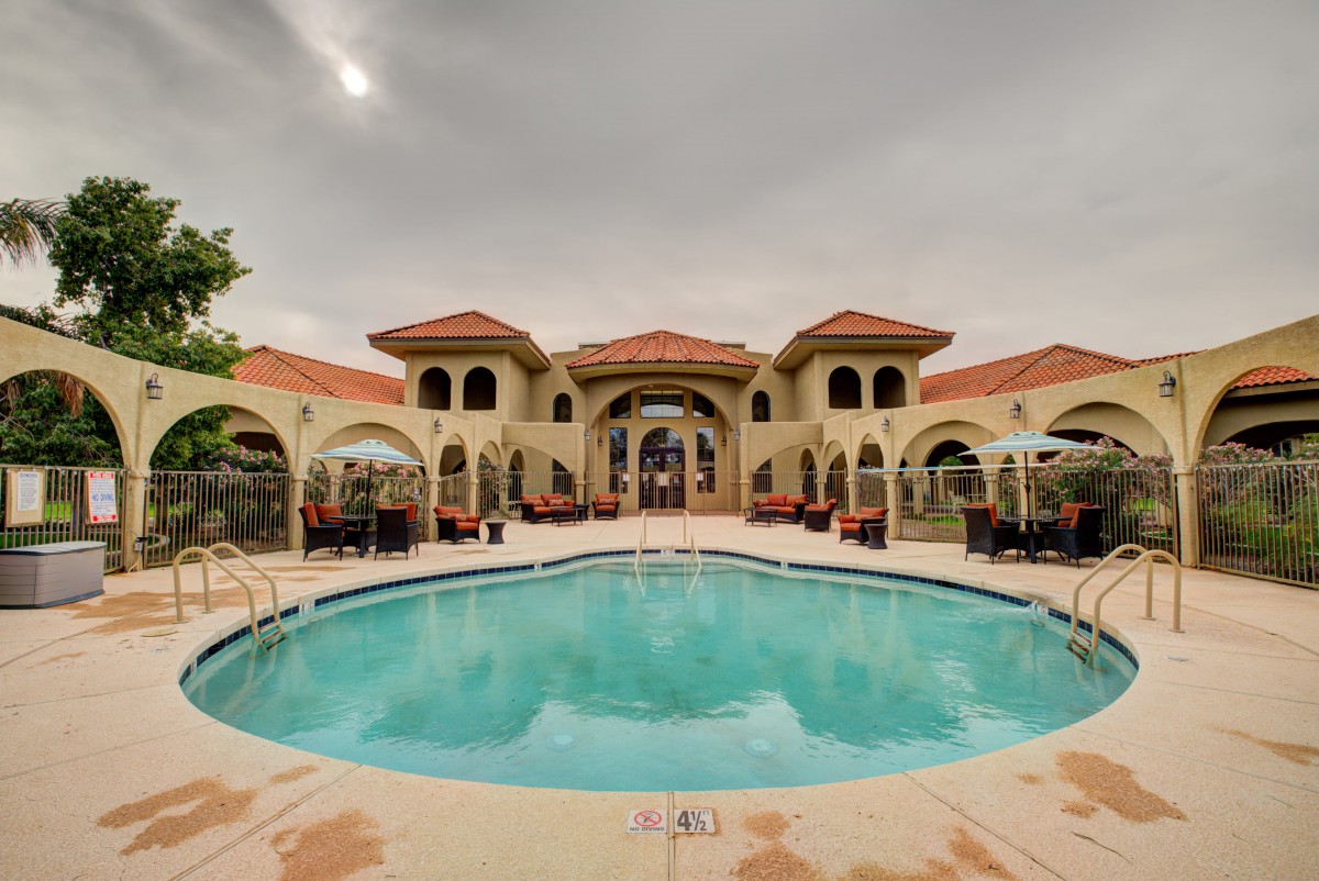 A luxurious mansion with a large swimming pool and elegant architectural design.