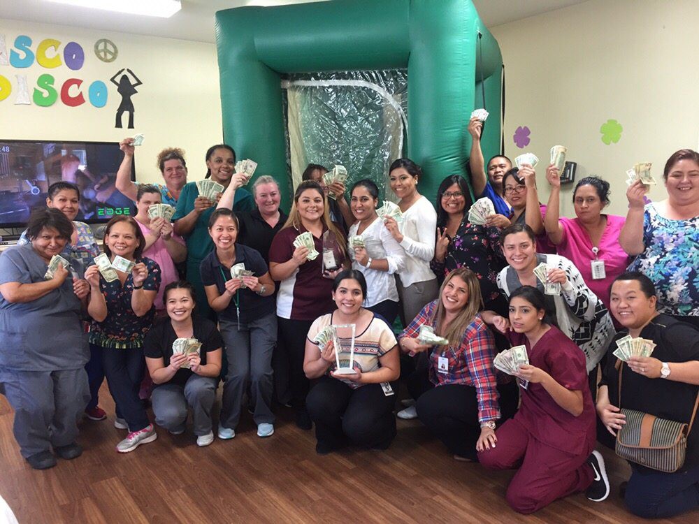 A group of people smiling and celebrating together indoors.