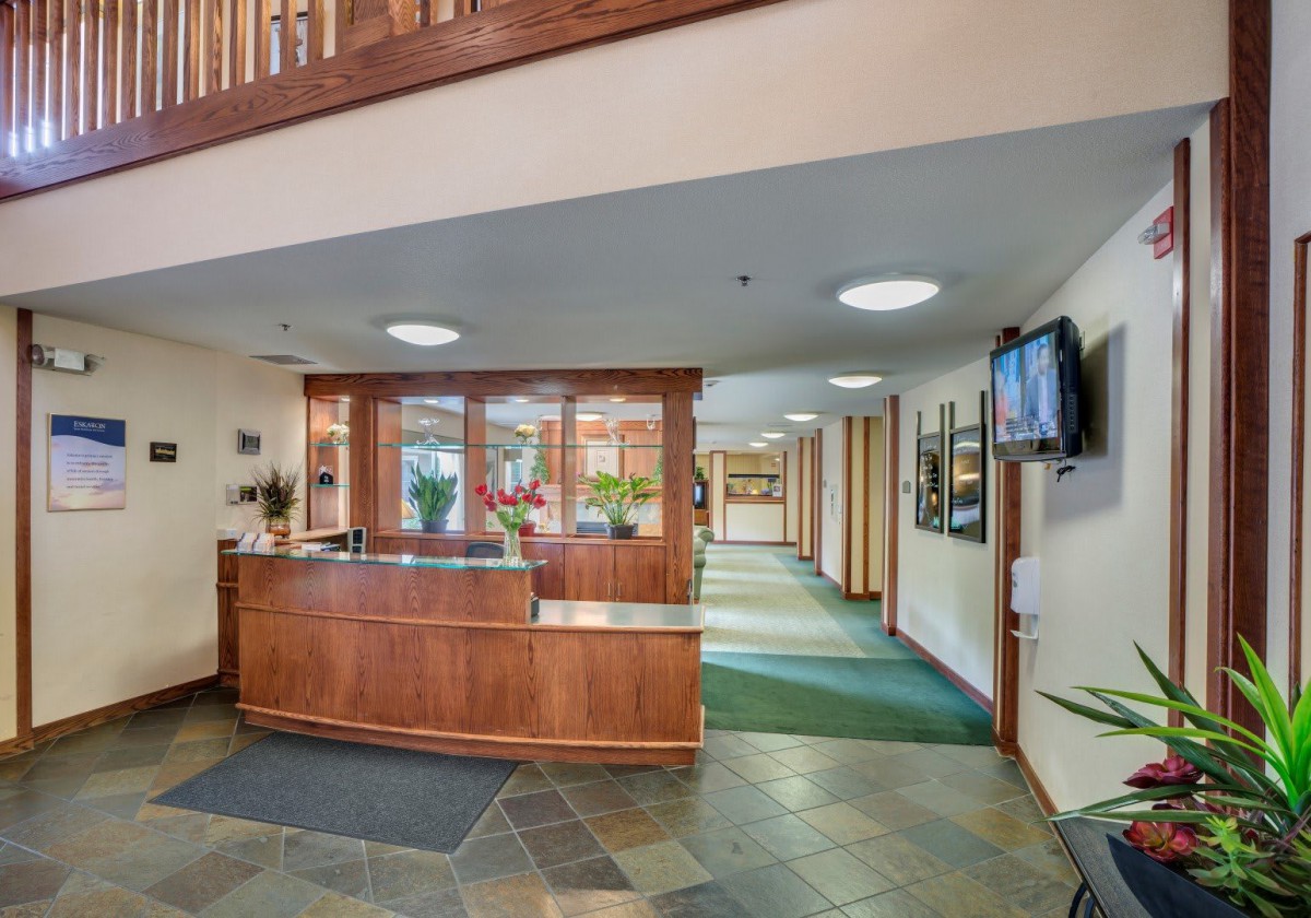 Reception area with a wooden desk and corridor.