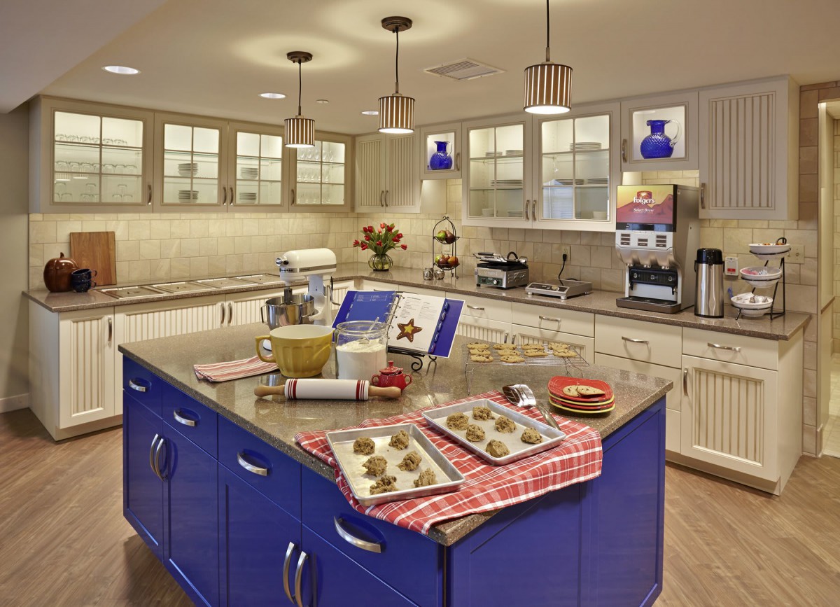 A spacious kitchen with a blue island, baking cookies on trays.