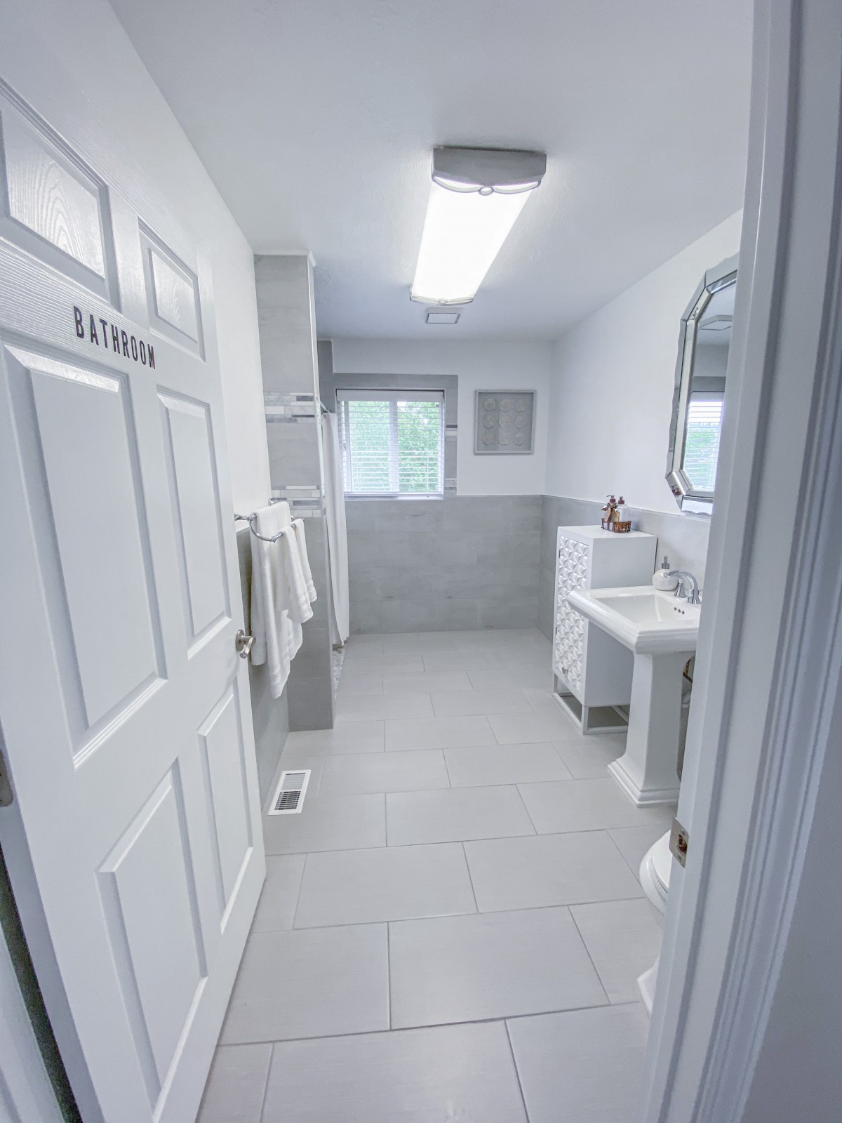 A modern, clean bathroom with white interior and fixtures.