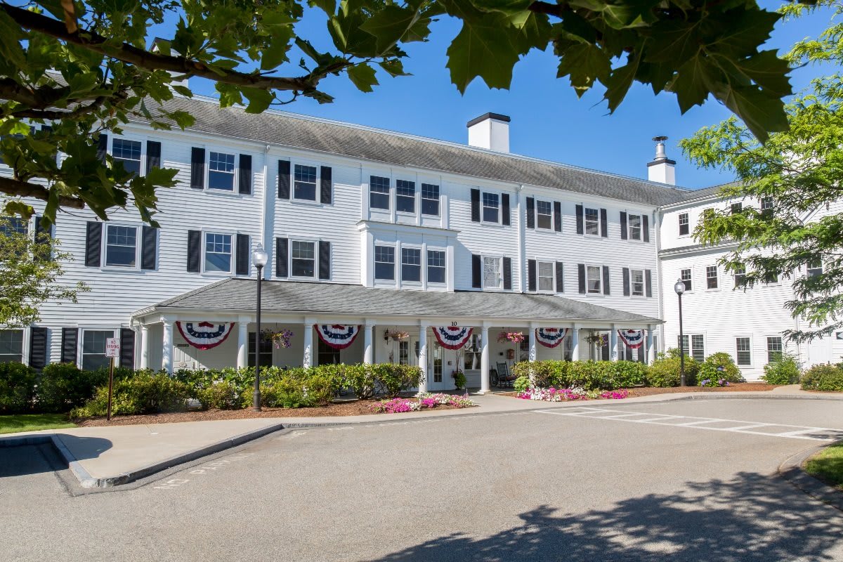 A large white hotel building with multiple windows and decorative patriotic bunting at the entrance.