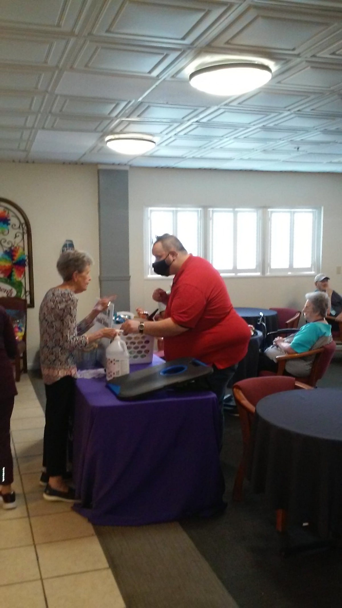 A community volunteer event with people interacting indoors.