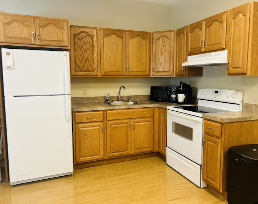 A cozy kitchen featuring wooden cabinets and essential appliances.