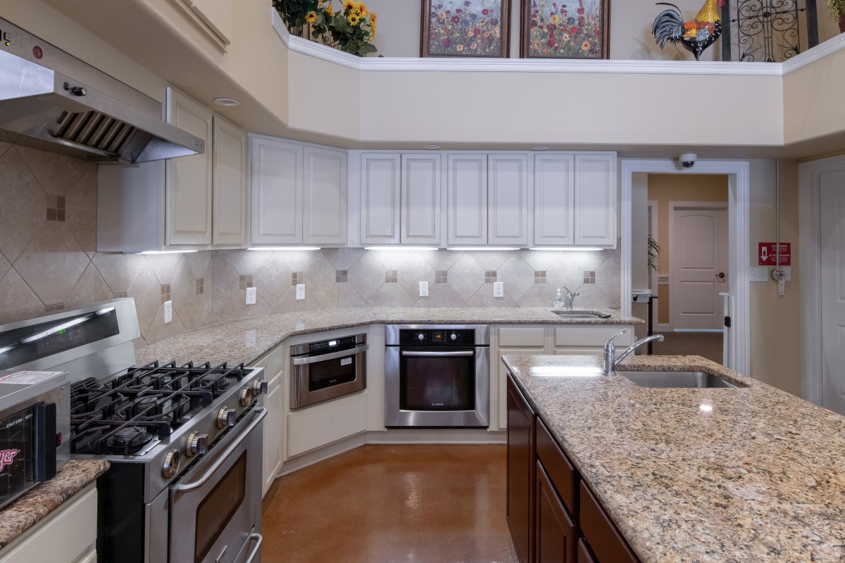 A modern kitchen with granite countertops and stainless steel appliances.
