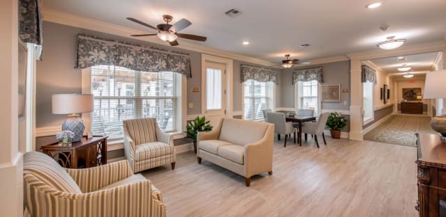 A cozy, well-lit living room with beige furniture and large windows.