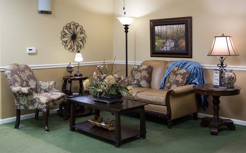 A cozy living room with a comfortable sofa, decorative cushions, and wall art creating a warm atmosphere.