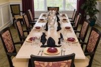 An elegantly set dining table with formal place settings and decorative napkins.