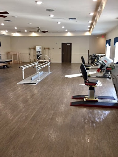 A spacious physical therapy gym equipped with exercise machines and rehabilitation tools.