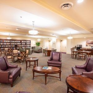 A cozy library seating area with comfortable chairs and bookshelves in the background.