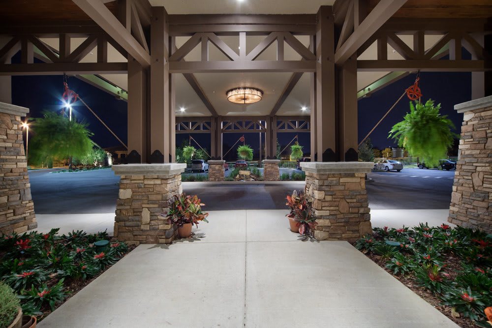 Elegant entrance with stone columns and night lighting.
