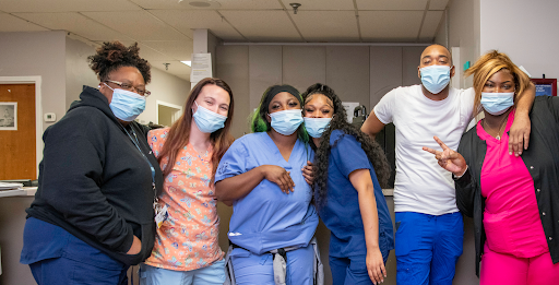A group of healthcare professionals posing together in a hospital setting, showcasing their camaraderie and dedication.