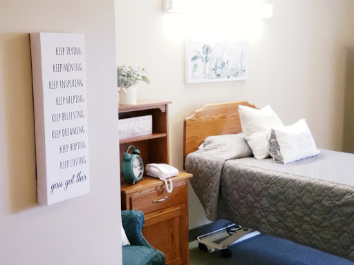 A cozy hospital room featuring a comfortable bed and inviting decor.