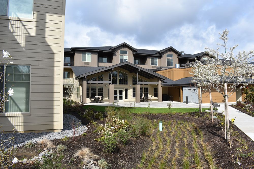 A modern residential building with landscaped gardens and a spacious front entrance.