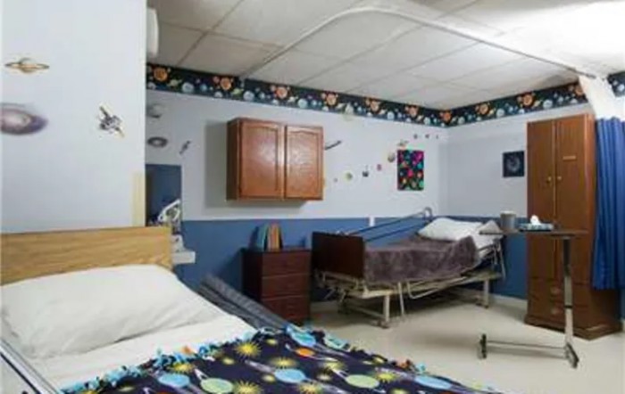 A hospital room with two beds and medical equipment.