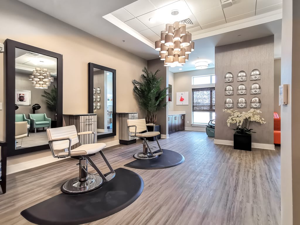 A modern salon interior with stylish chairs and mirrors, complemented by contemporary lighting.