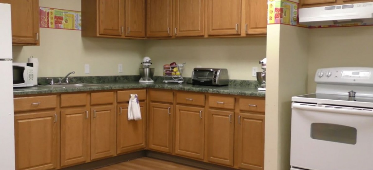 A kitchen with wooden cabinets and appliances on the countertop.
