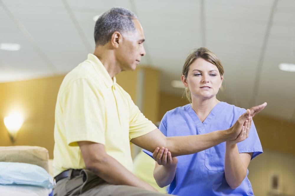 A healthcare professional assists an elderly patient with physical therapy exercises.