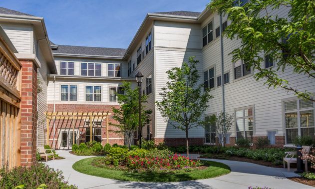 A modern building with large windows and landscaped greenery.