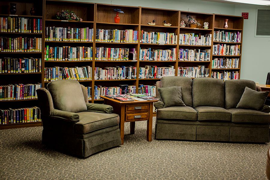 Cozy reading nook in a library with bookshelves and comfortable seating.
