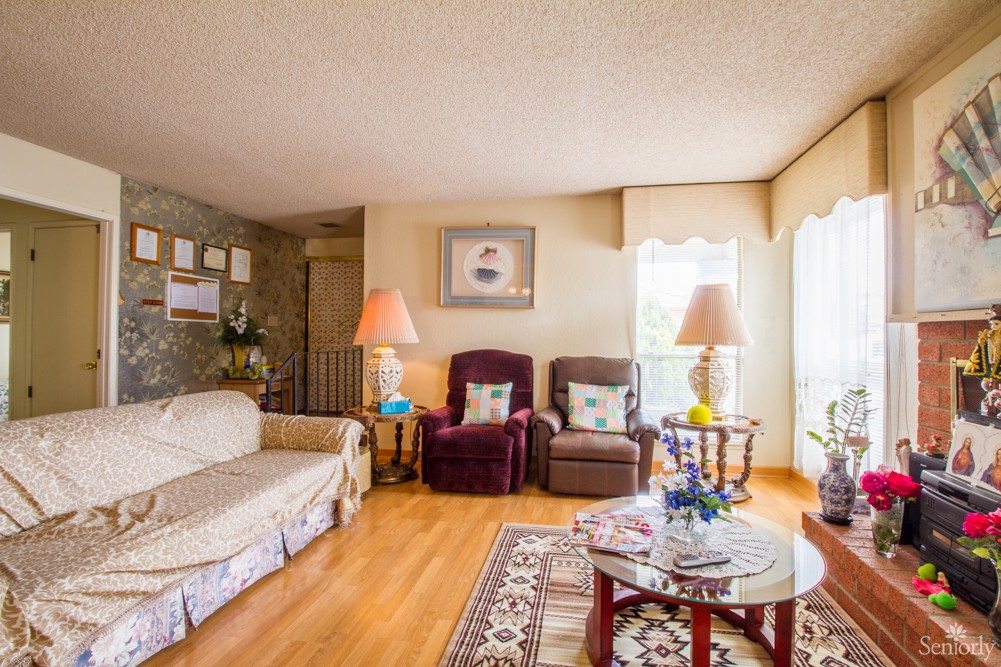 A cozy living room with a sofa, two armchairs, and a coffee table on a wooden floor.