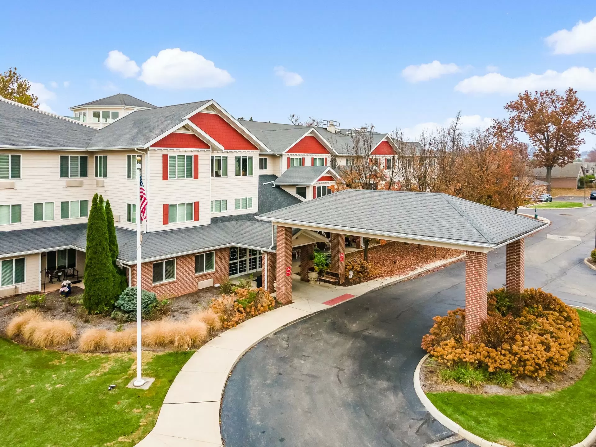A senior living facility with a landscaped entrance and curved driveway.
