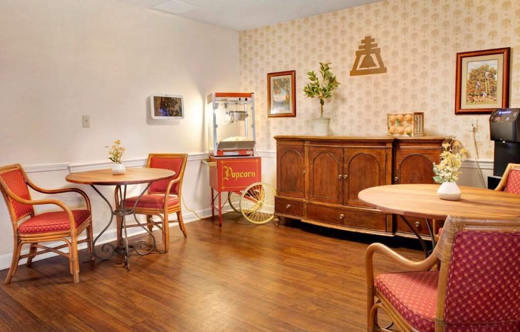 A vintage-style dining area with a popcorn machine and wooden furniture.