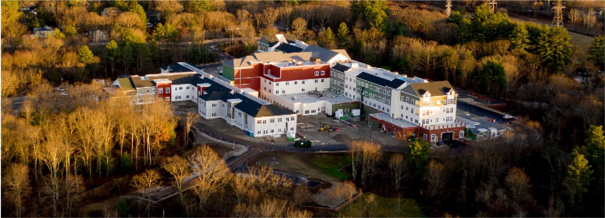 An aerial view of a large building complex surrounded by trees.