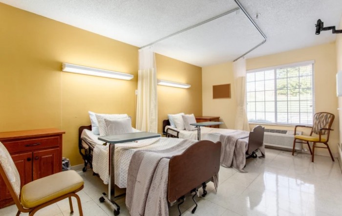A hospital room with two patient beds and medical equipment.
