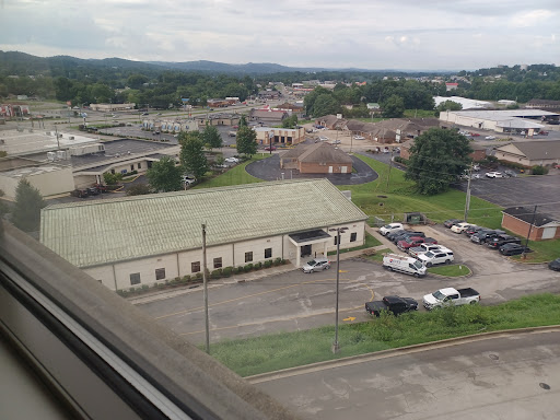 A view of a small town showing various buildings and green landscapes in the background.