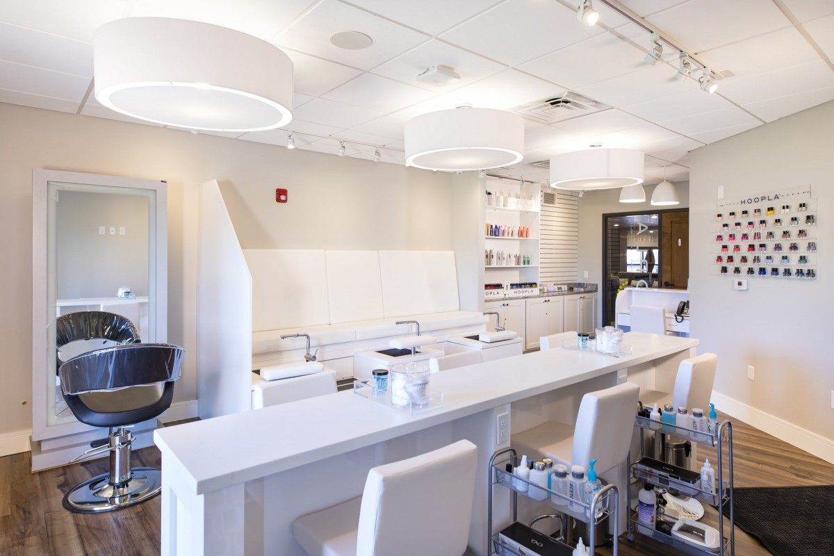 A modern and stylish beauty salon interior with white decor and spa equipment.