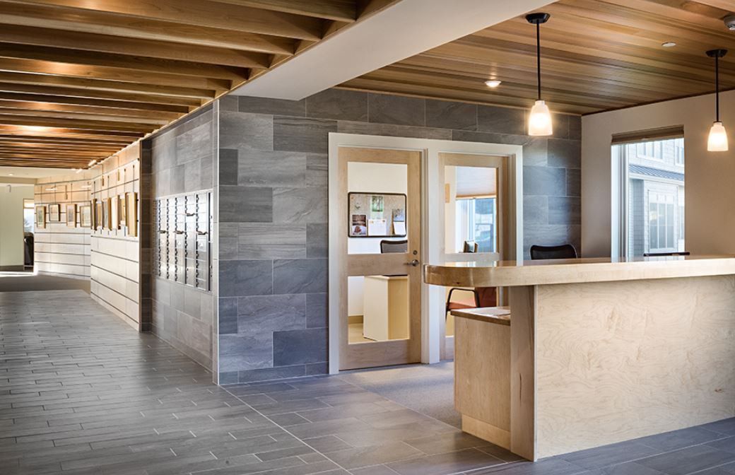 A modern office interior featuring a wooden reception desk and sleek design elements.